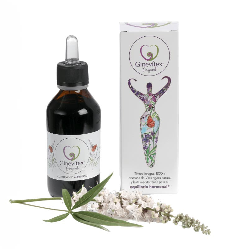 A 100ml bottle of Ginevitex food supplement on white background with a branch of the plant Vitex agnus castus laying in front and the package box on the side