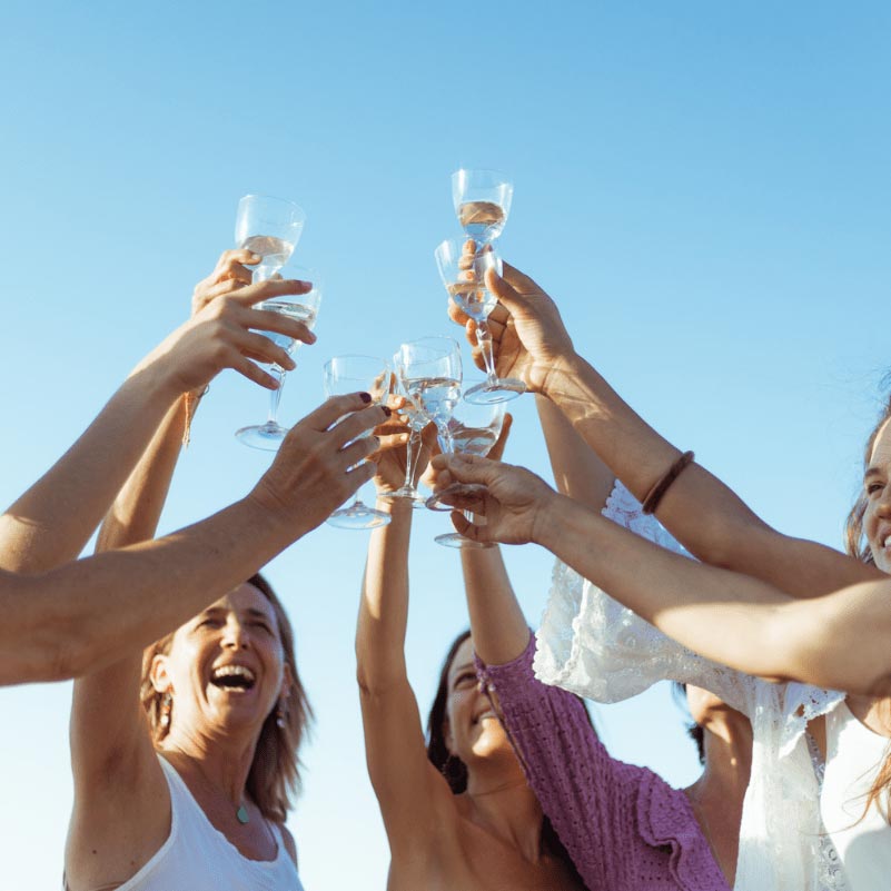 8 women rising their glass with Ginevitex elixir making a toast for change and life