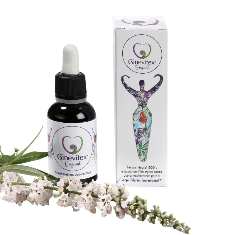 A 30ml bottle of Ginevitex food supplement on white background with a branch of the plant Vitex agnus castus laying in front and the package box on the side